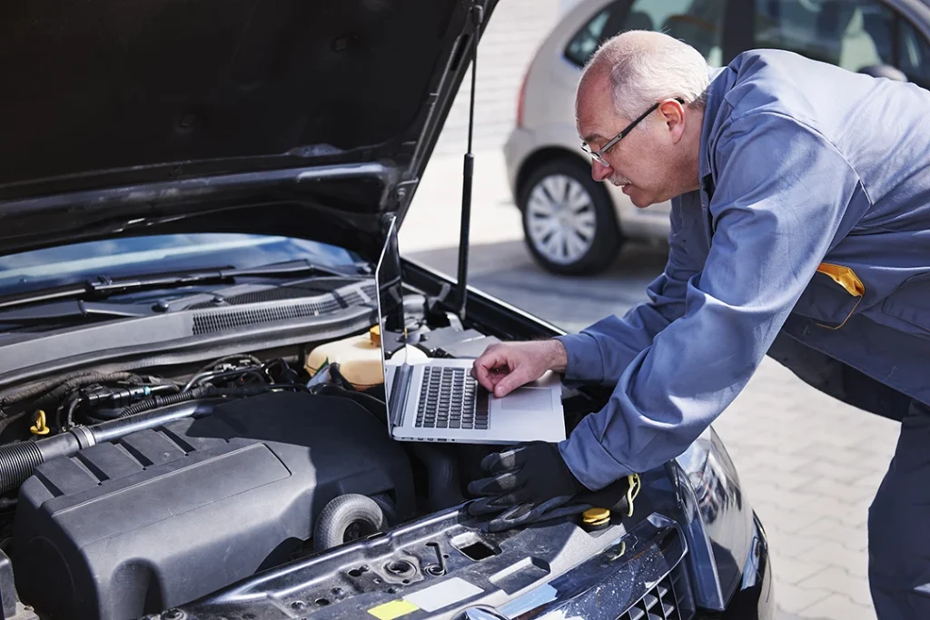 Technician check out car engine for mobile auto inspection in Houston with the hood open.