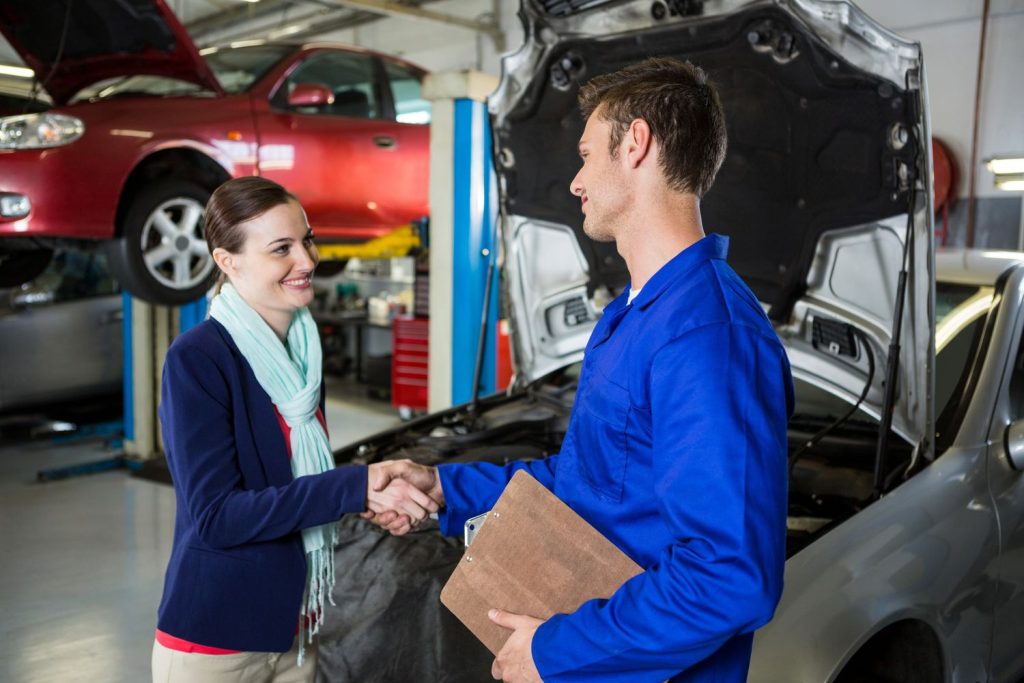 A mechanic and client shaking hands after a pre purchase inspection of a car in Houston, ensuring vehicle reliability.