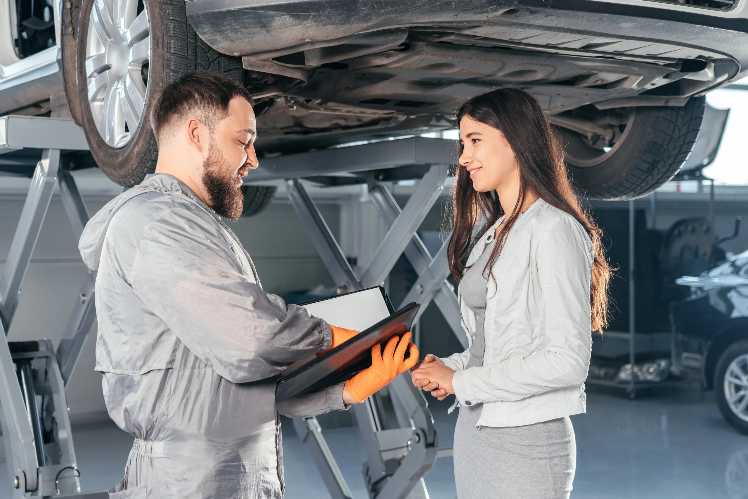 Technician conducting a Tesla used car inspection Houston while discussing findings with the client.