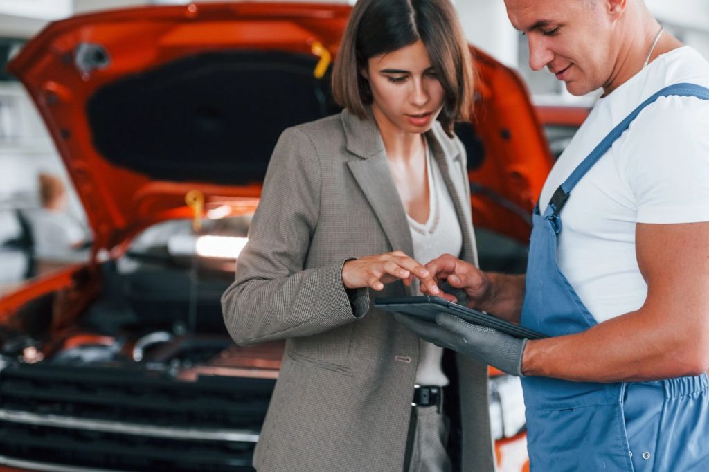 Third party inspection includes client consultation with technician. Tablet used to explain vehicle condition and repairs.