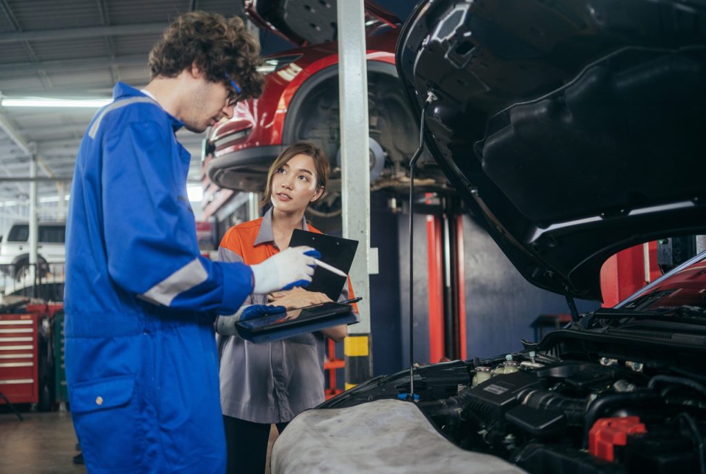 Expert technicians conduct a pre-purchase check used car service Houston using digital diagnostic tools in-shop.