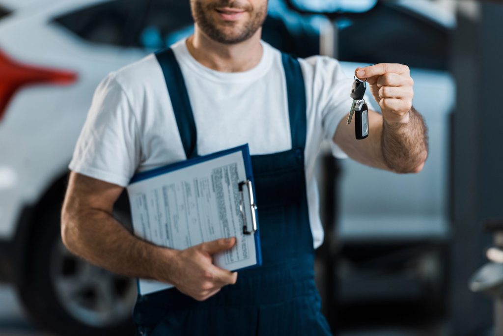 Mechanic holding keys after a used car check Houston service to ensure vehicle reliability for a local car buyer.